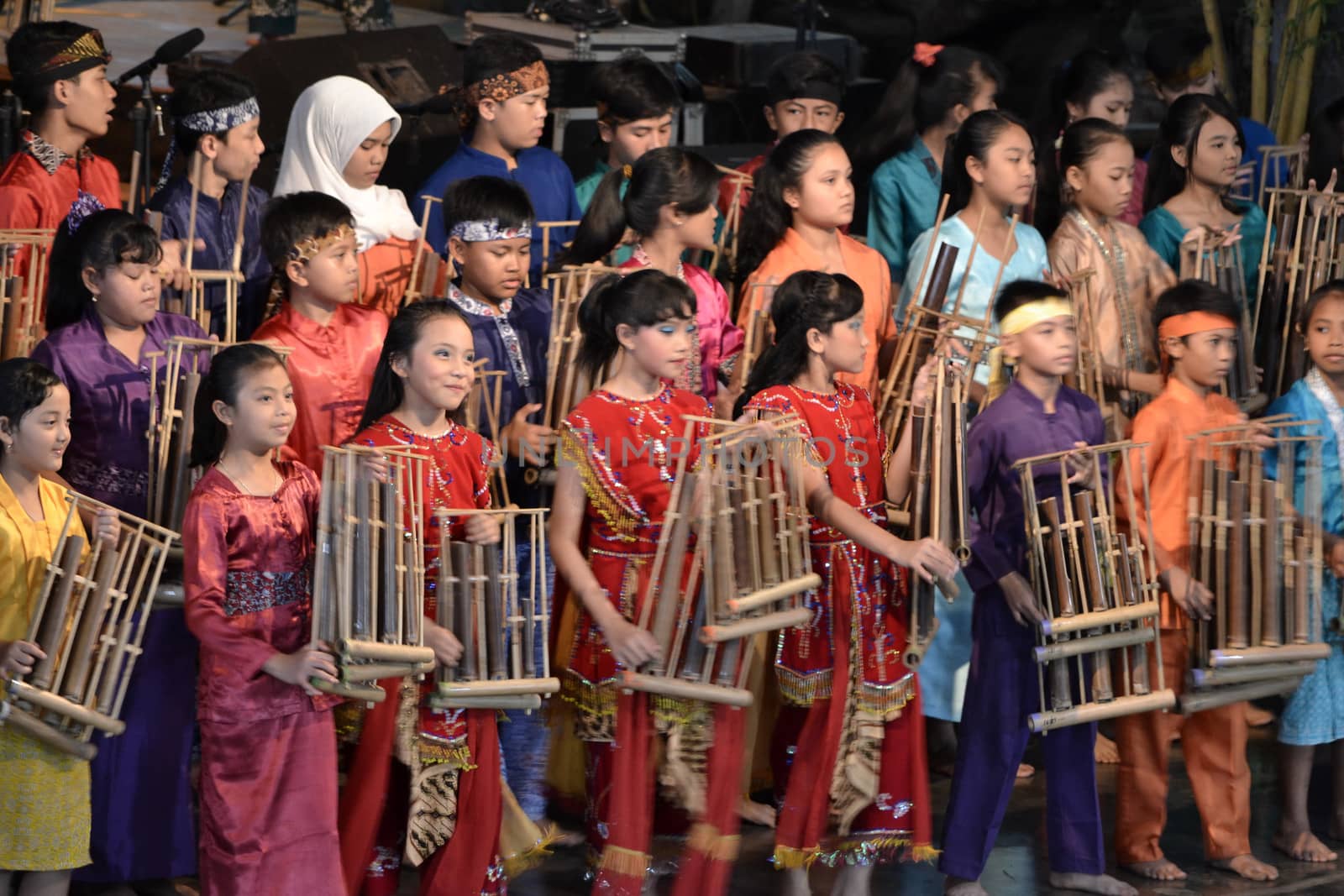 bandung, indonesia-june 16, 2014: kids playing angklung at saung angklung udjo. angklung is traditional musical heritage made from bamboo and worldwide recognize originally from indonesia.
