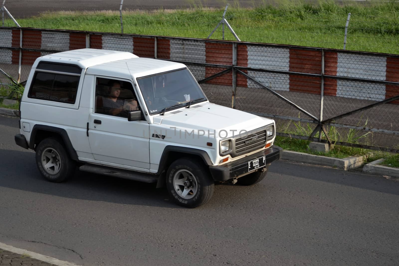 bandung, indonesia-june 16, 2014: white colored daihatsu taff gt cruising on the road.