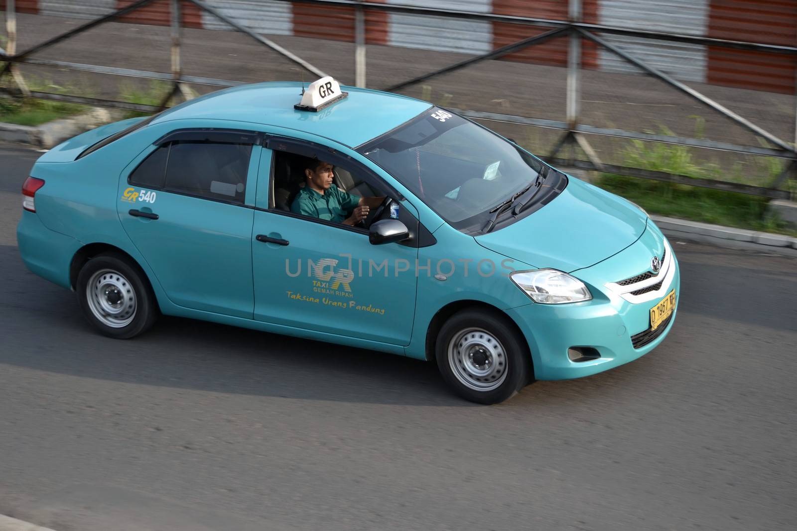 bandung, indonesia-june 16, 2014: gemah ripah taxi cruising on the road.