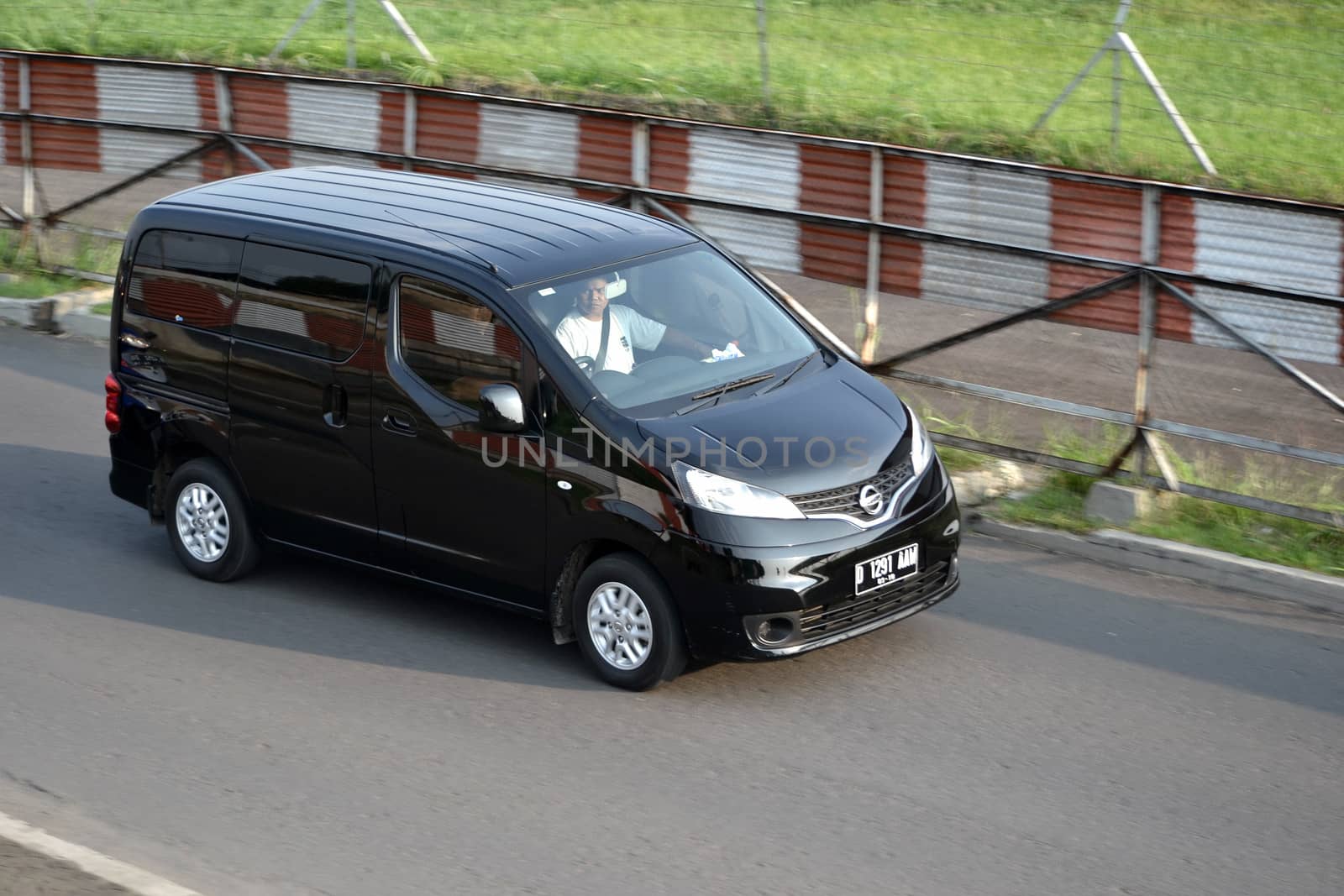 bandung, indonesia-june 16, 2014: black colored nissan evalia cruising on the road.