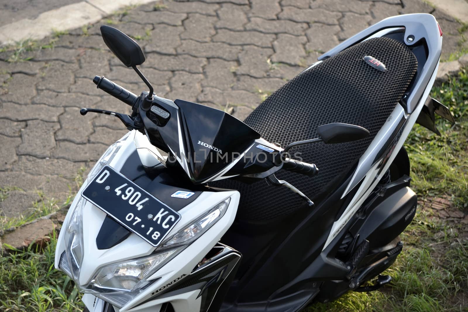 bandung, indonesia-june 16, 2014: honda vario cbs techno motorcycle parking at the side road.