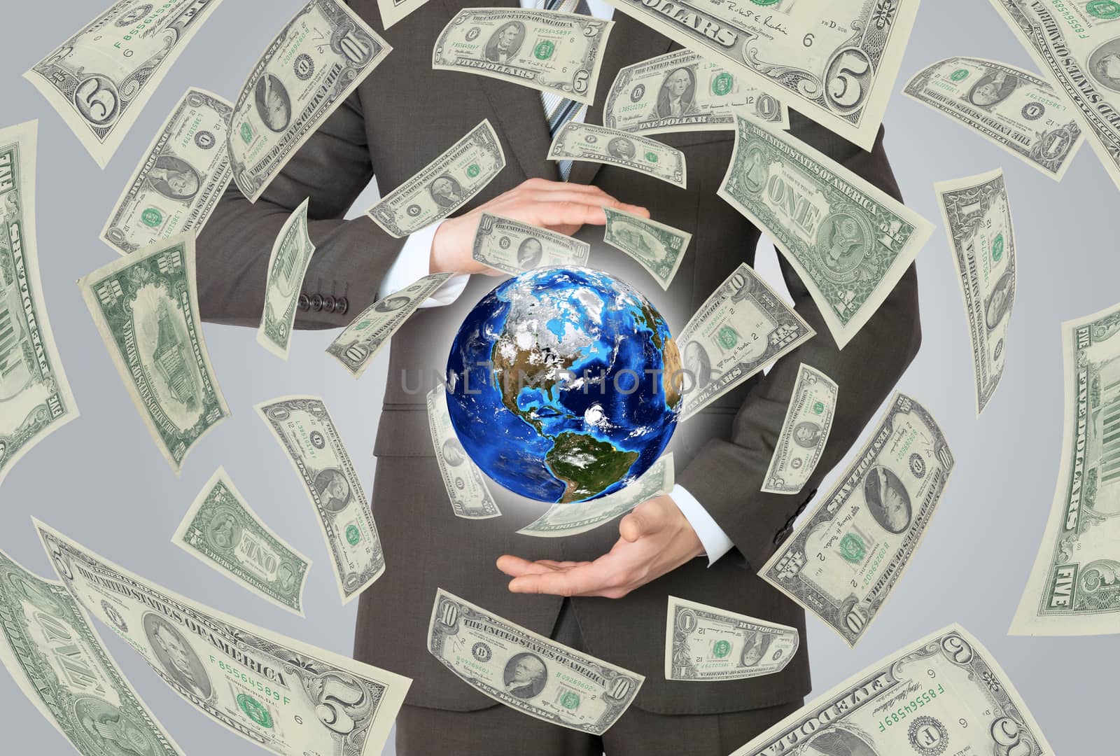 Businessman in a suit holding a earth. Money falling around