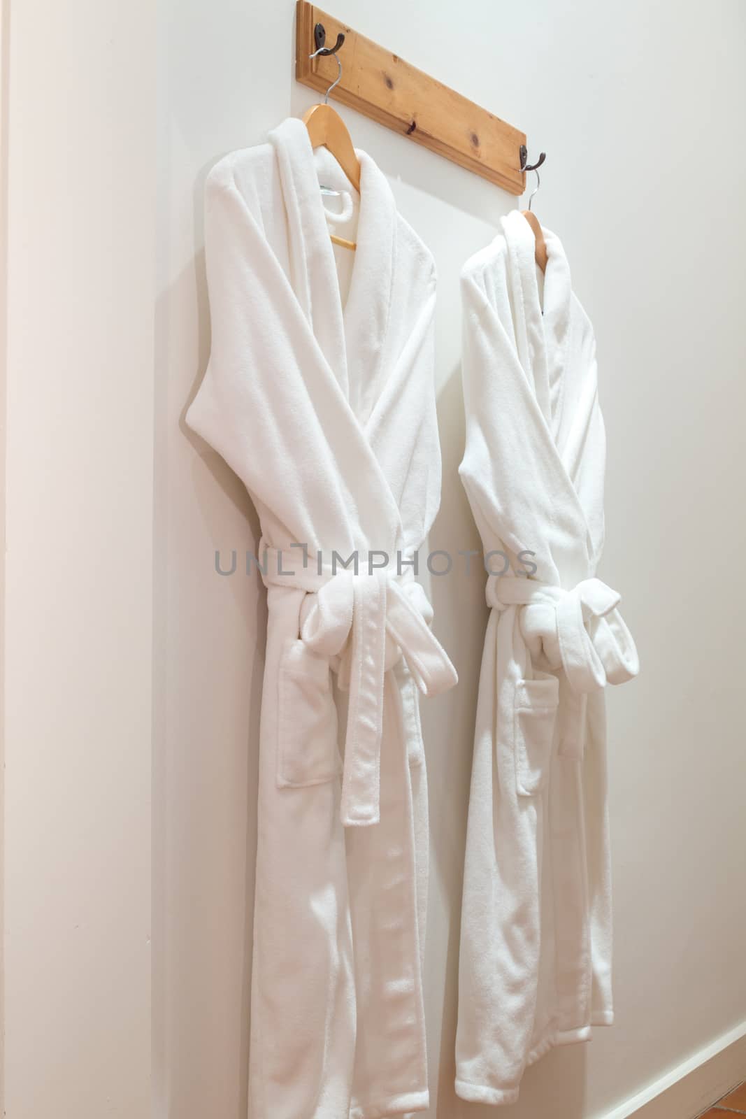 Bathrobes hanging on the wall by derejeb
