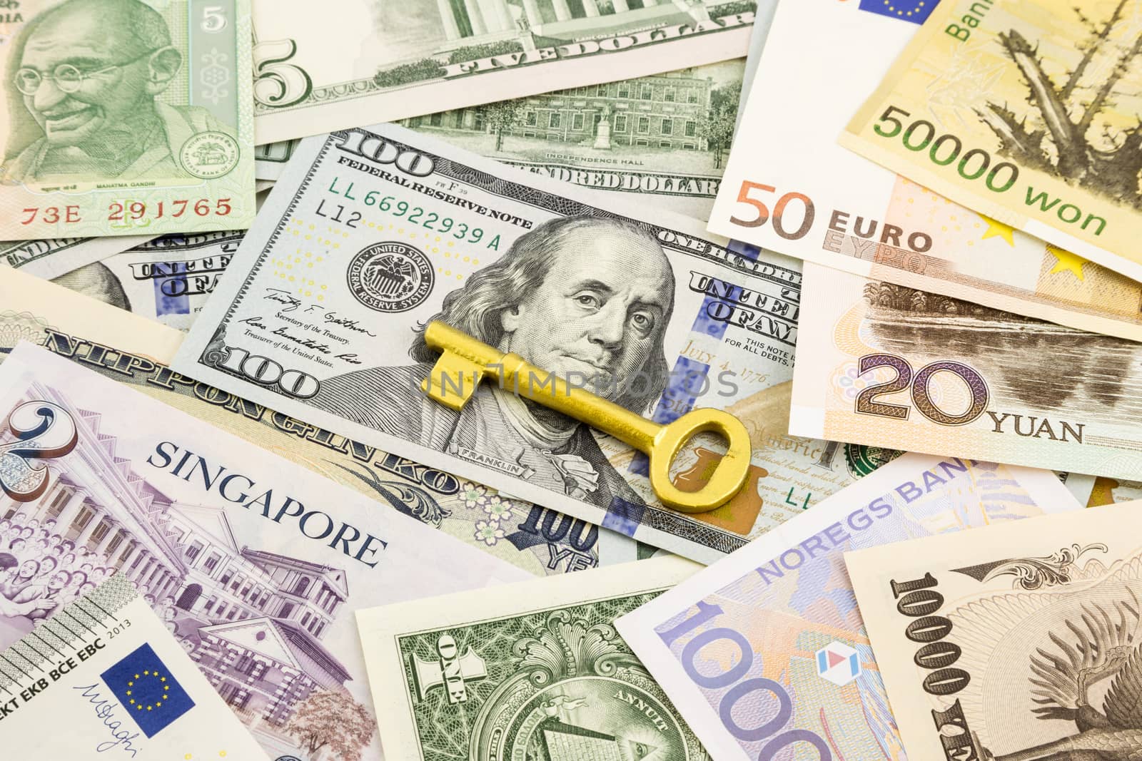 golden key  and world currency money banknotes  by vinnstock