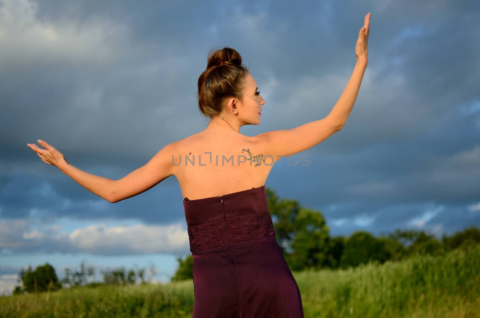 Beautiful girl from Poland, outdoor portrait. Young female model posing with different hands gesture. Blue sky with single clouds and green fields as background.