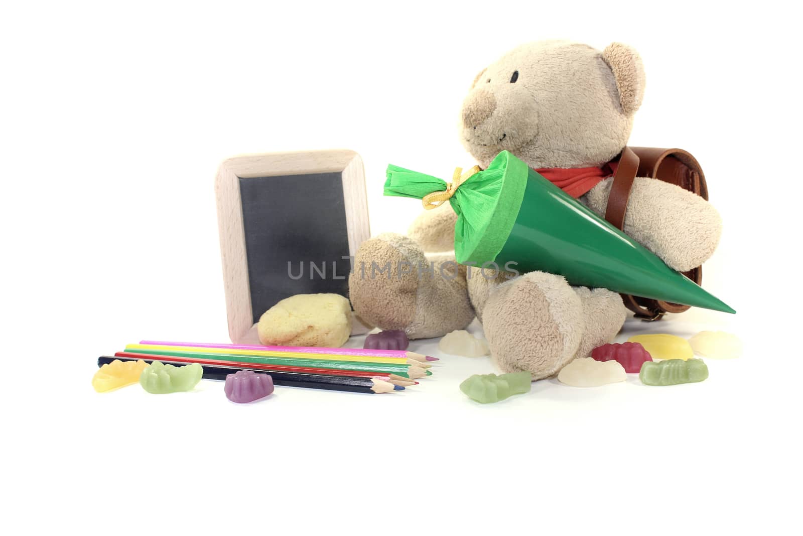 Teddy bear with school bag, wallet, candy, pens and board on a light background