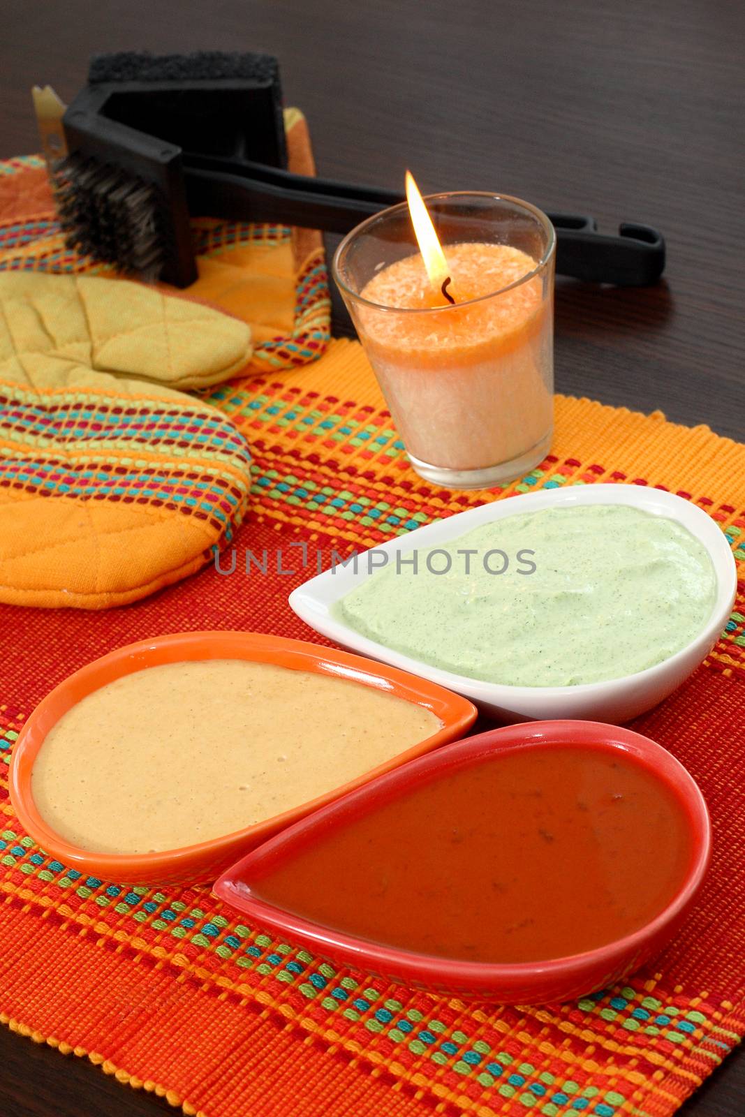 Three types of barbecue sauce, red, white, orange arranged on the table