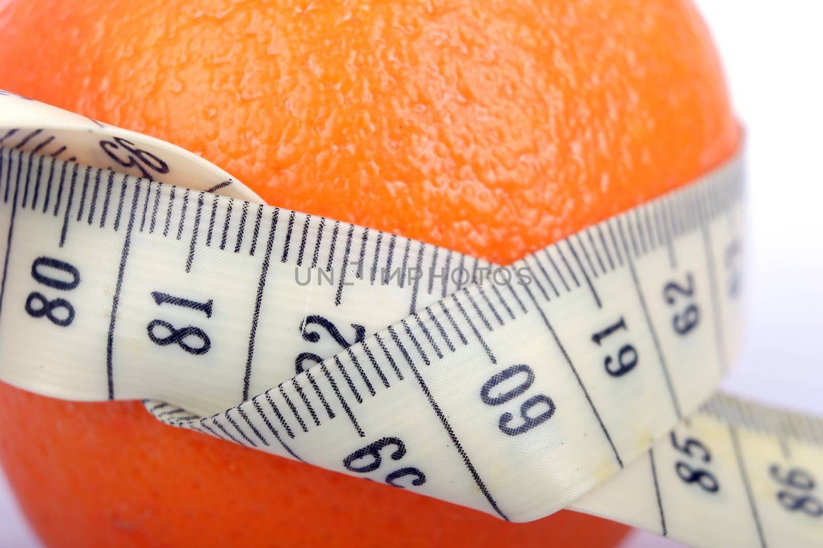 Supple orange with a tape measure - symbol of the fight against cellulite.