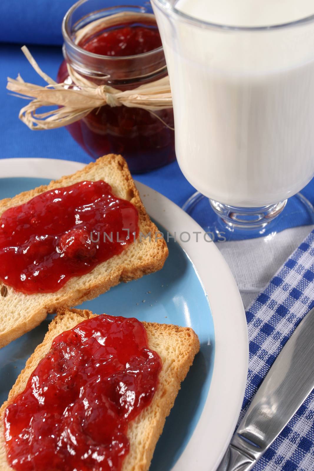 Homemade breakfast, toast with jam, a glass of milk and a jar of jam