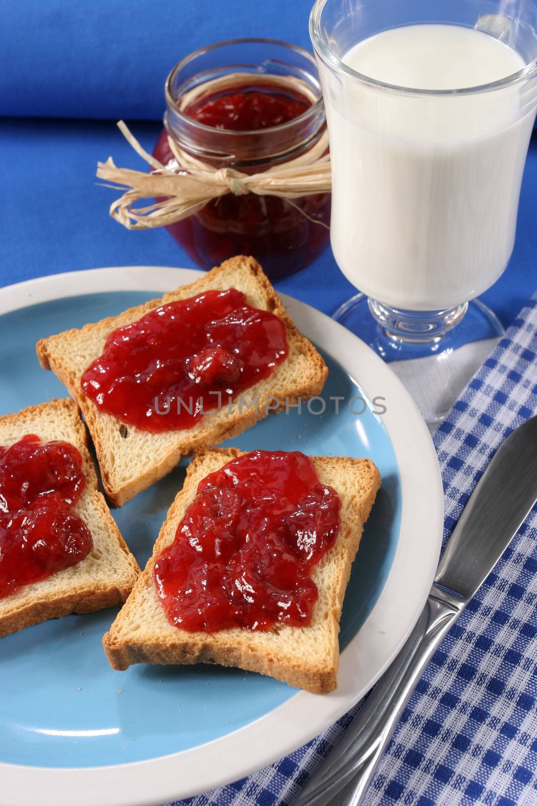 Homemade breakfast, toast with jam, a glass of milk and a jar of jam