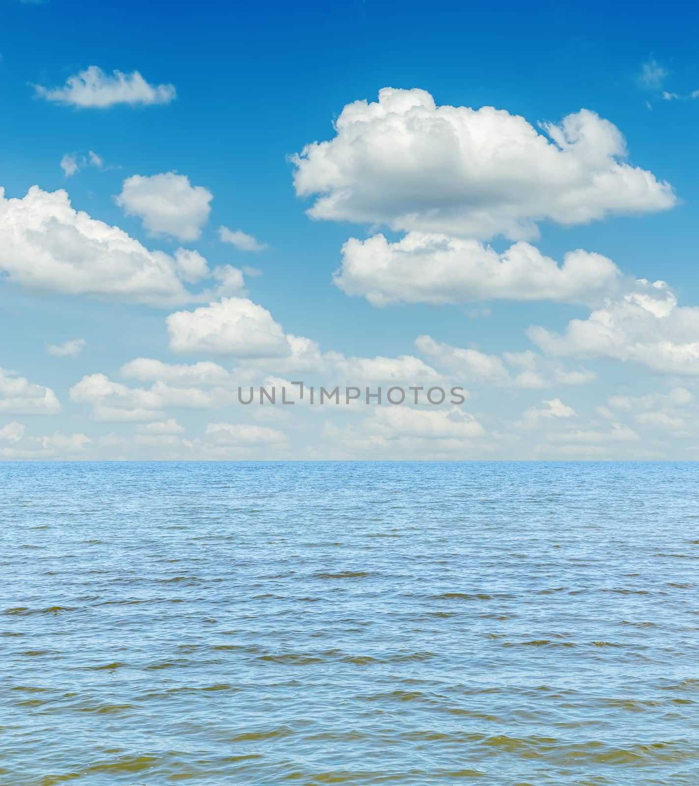 white clouds in sky over blue sea by mycola