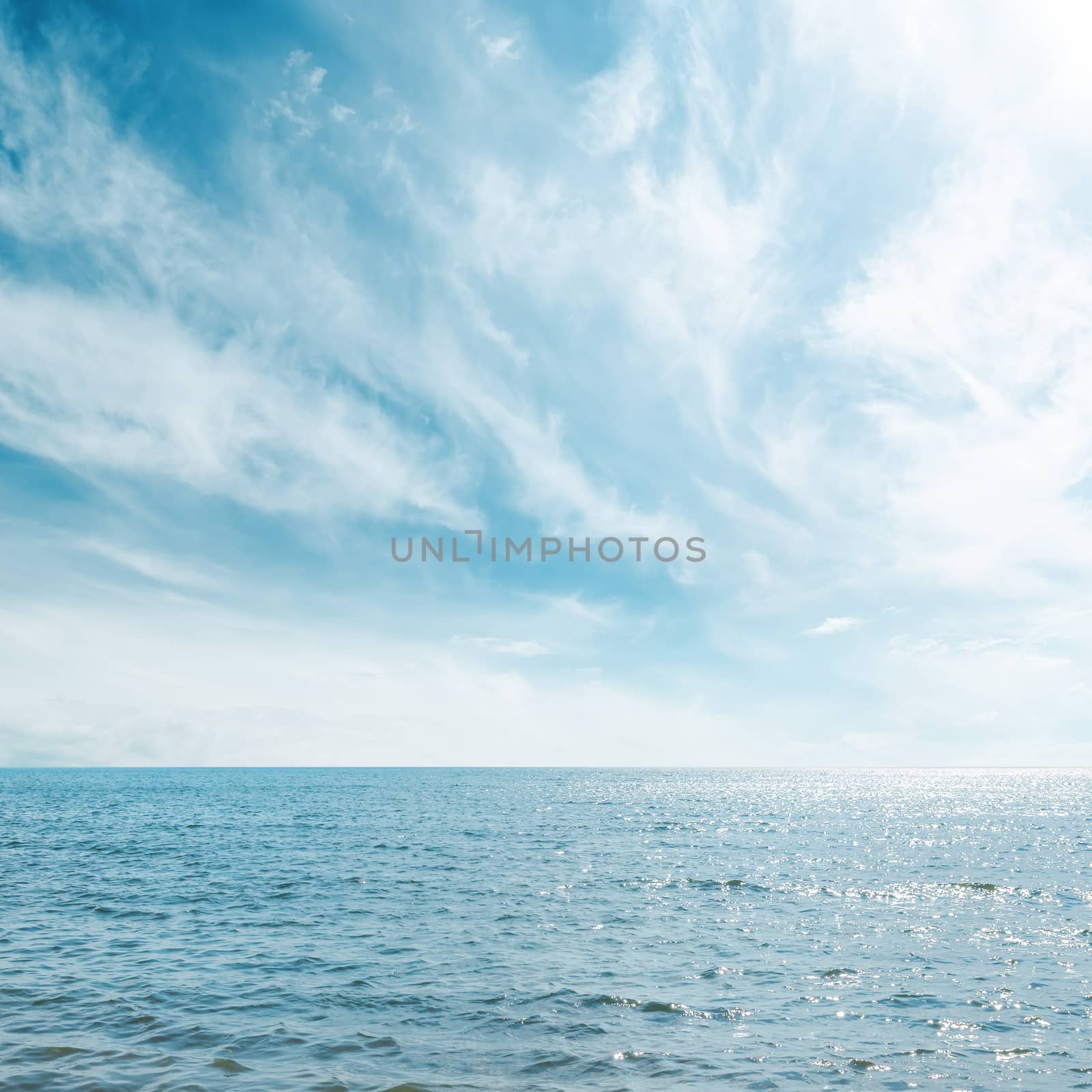 blue sea and cloudy sky over it