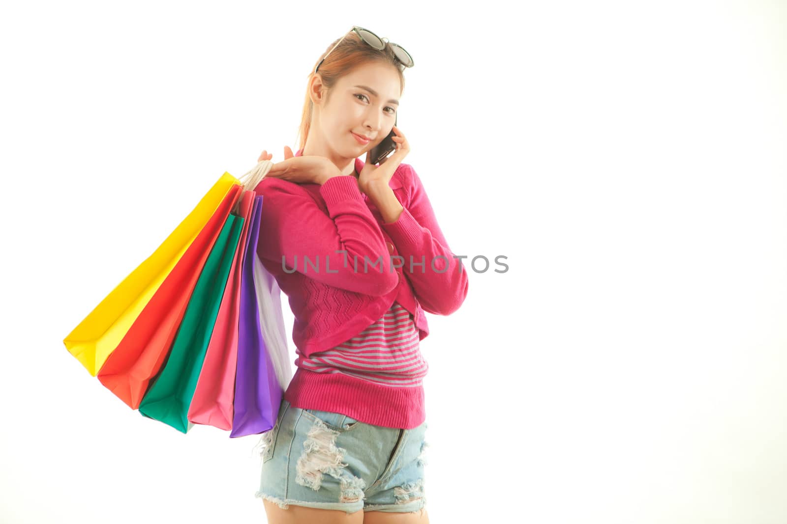 Shopping young asian woman talking on the phone looking happy isolated on white background