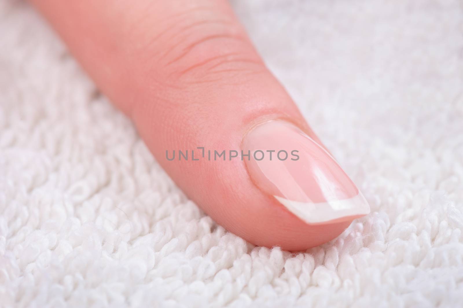Fingers with french manicure on white towel