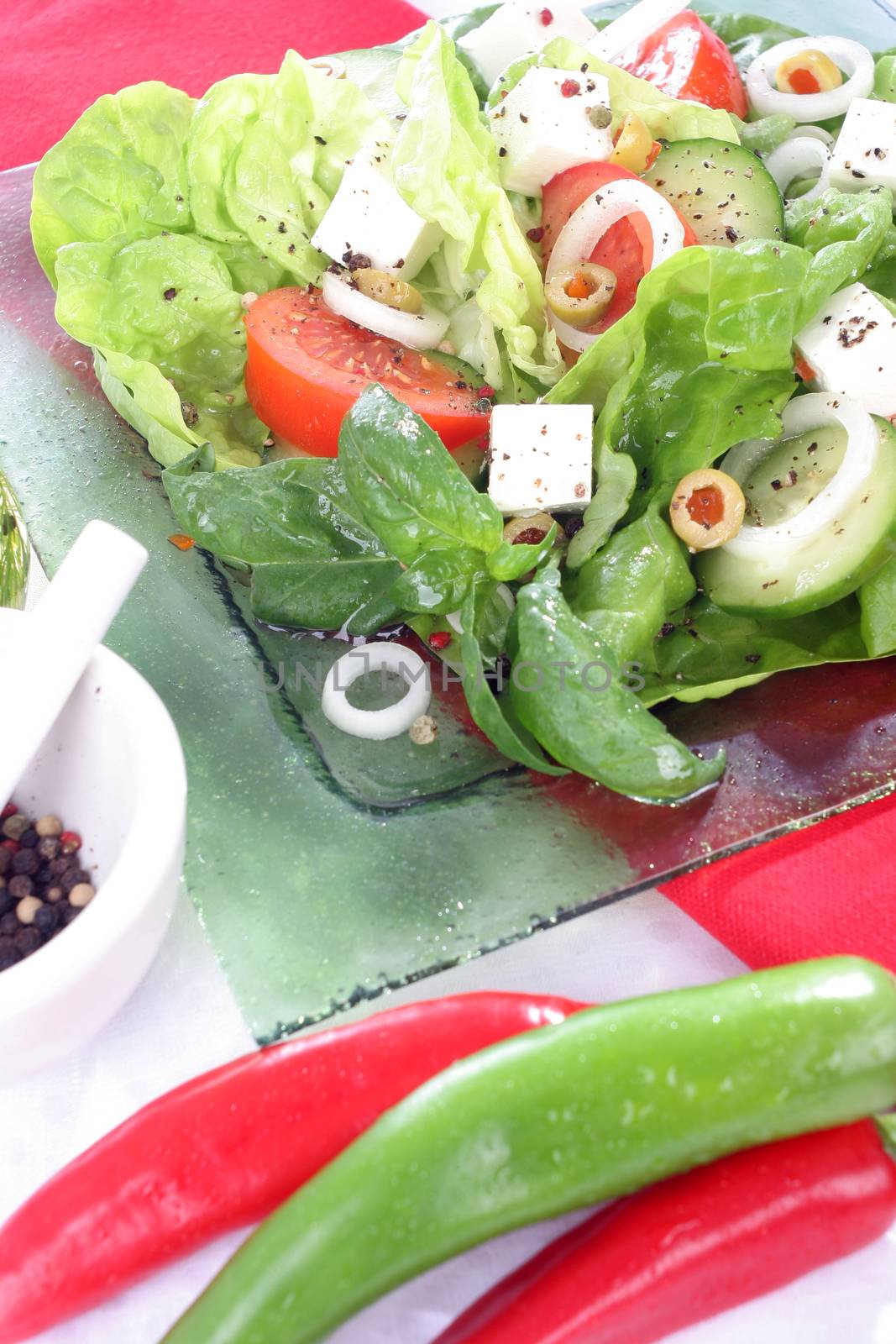 Salad with lettuce, tomato, cucumber, onion, olives clearing sauce.