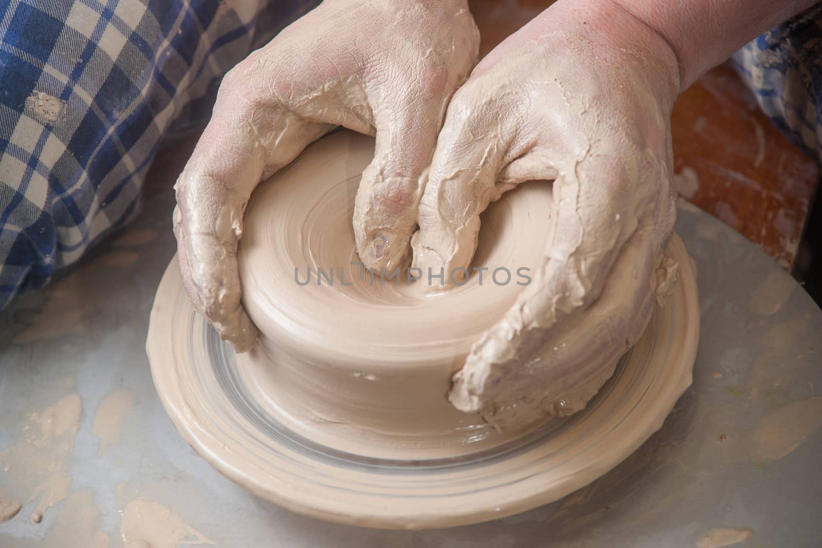 Hands of a potter, creating an earthen jar on the circle