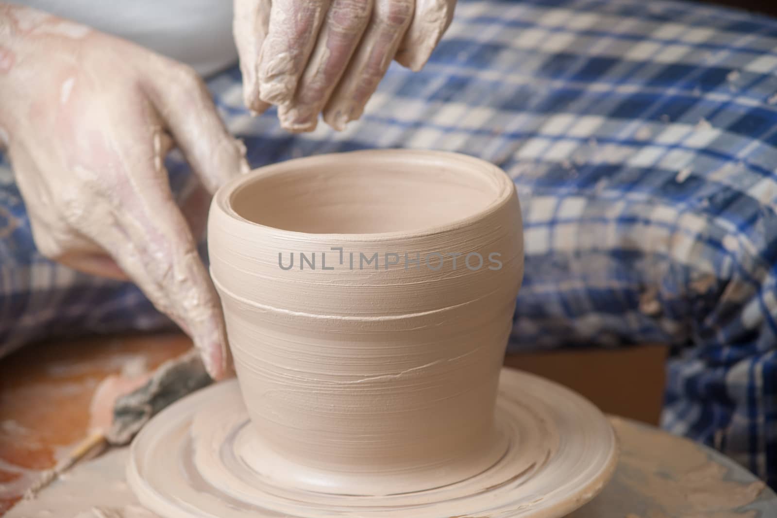 Hands of a potter, creating an earthen jar on the circle