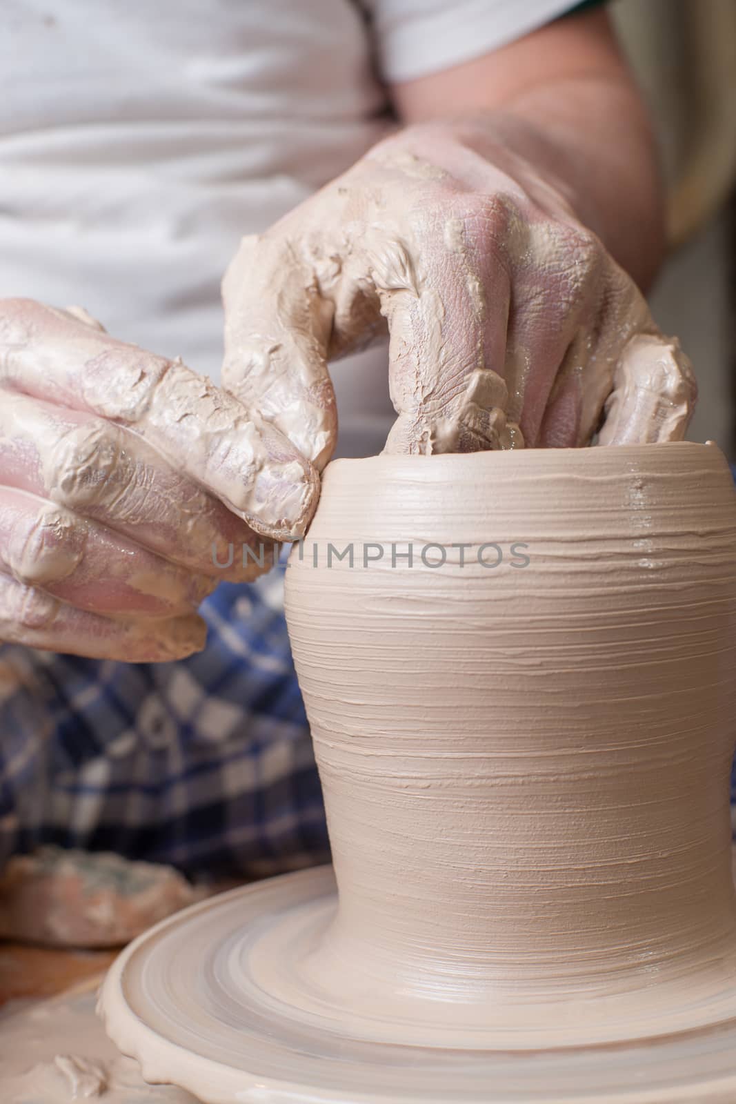 Hands of a potter, creating an earthen jar on the circle