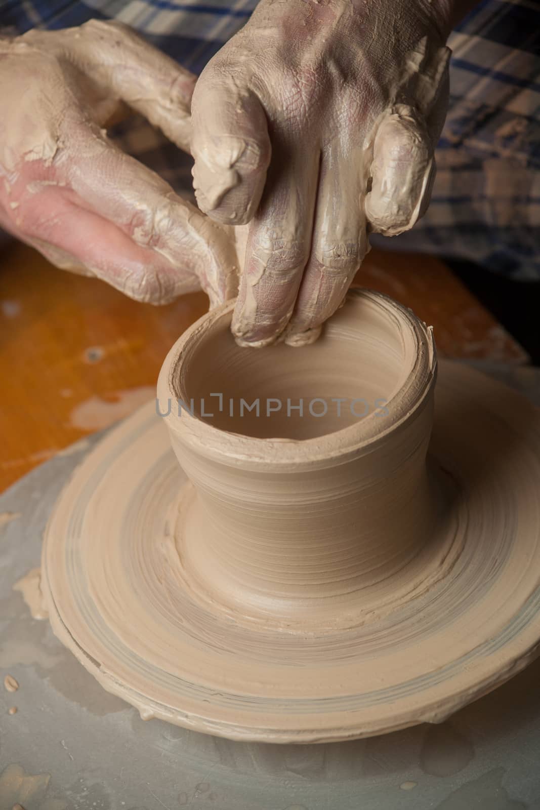 Hands of a potter, creating an earthen jar on the circle