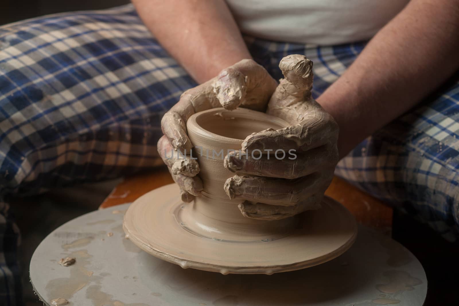 Hands of a potter, creating an earthen jar on the circle