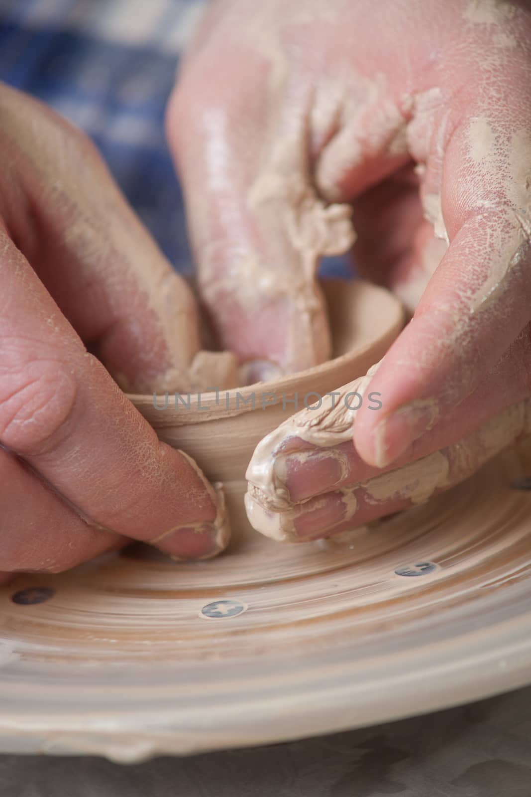 Hands of a potter, creating an earthen jar on the circle