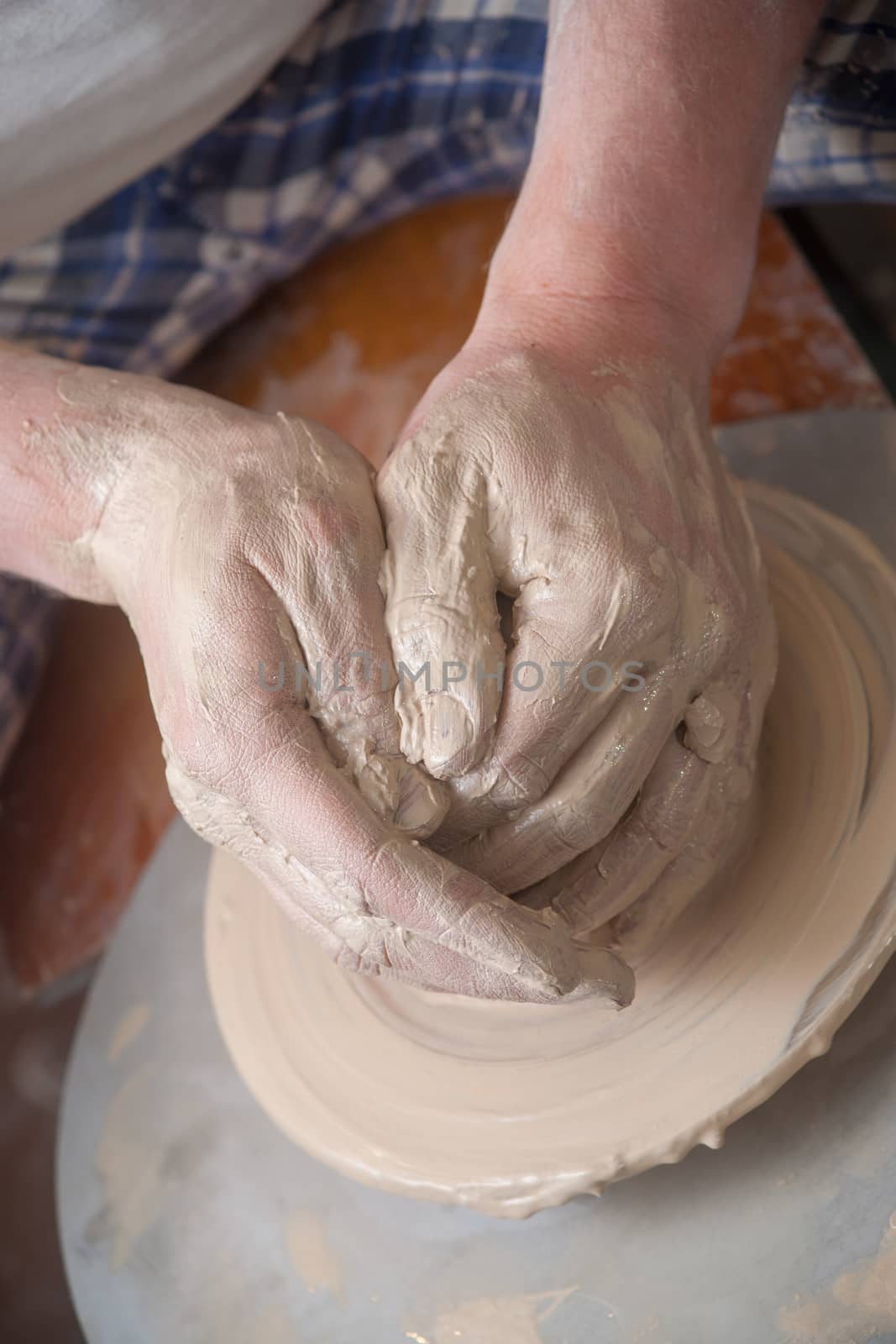 Hands of a potter, creating an earthen jar on the circle