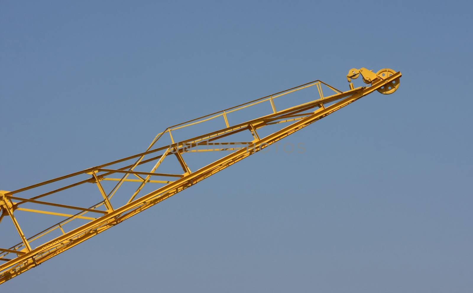 Yellow crane high in the blue sky