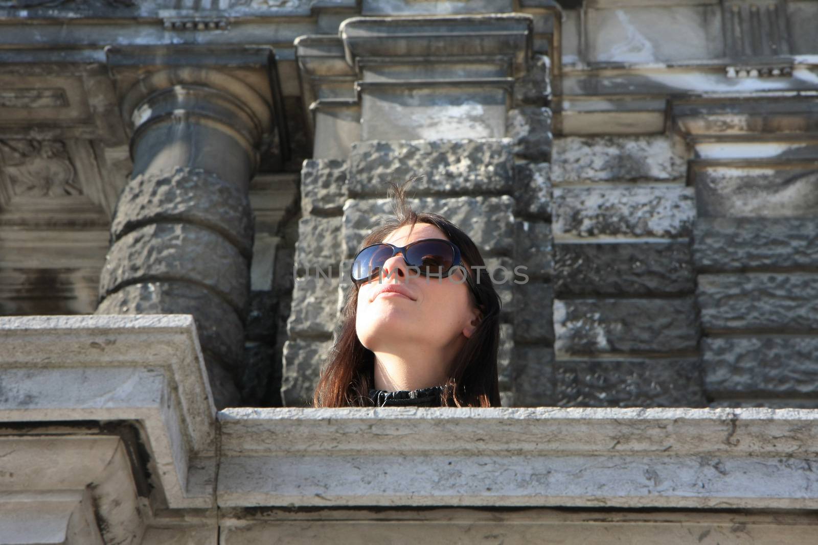 Young lady on the balcony of ancient building