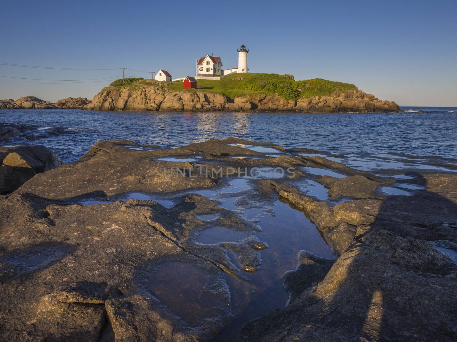 The Nuble lighthouse at sunset as seen from shore in York, Maine