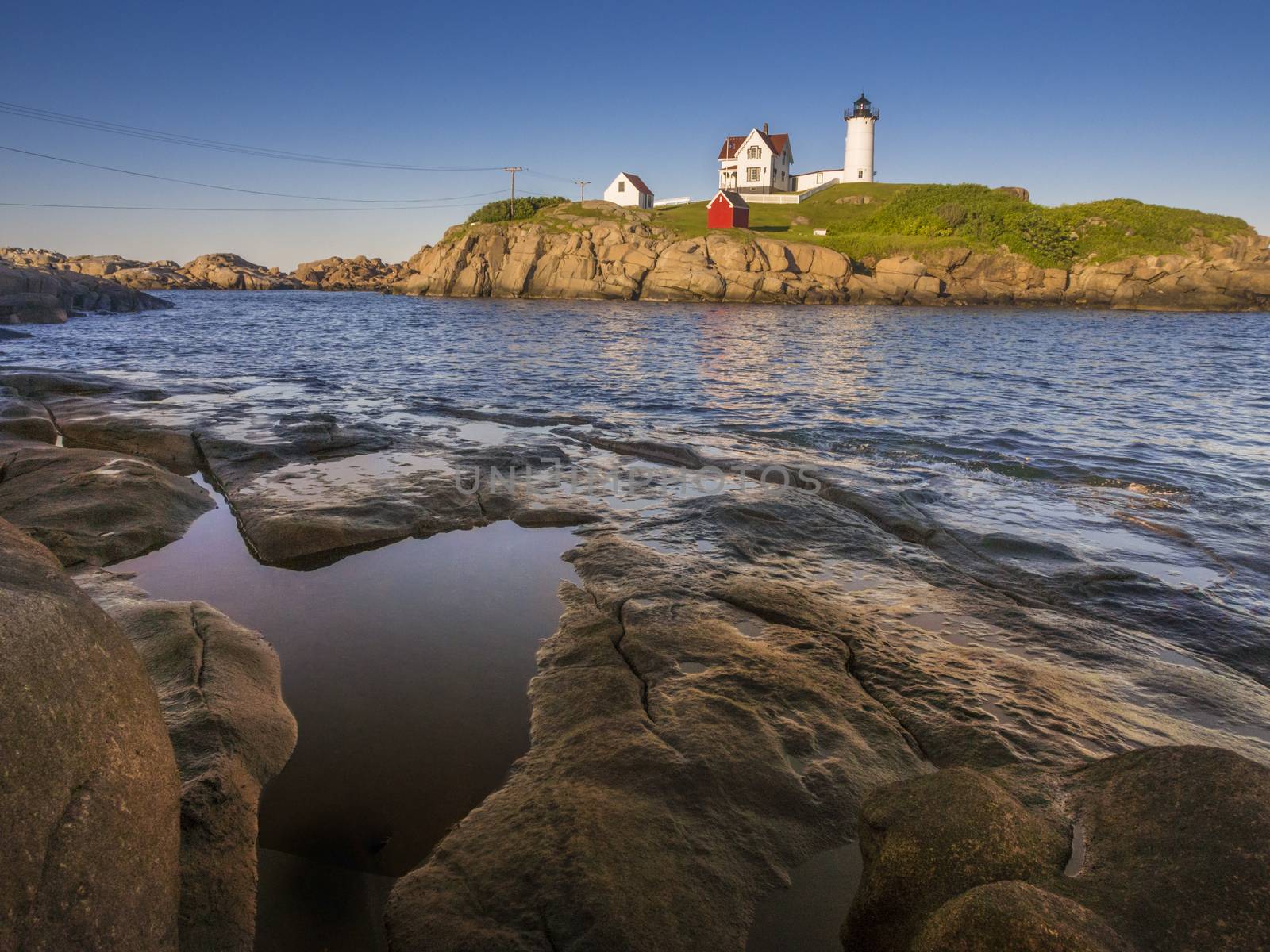 The Nuble lighthouse at sunset as seen from shore in York, Maine