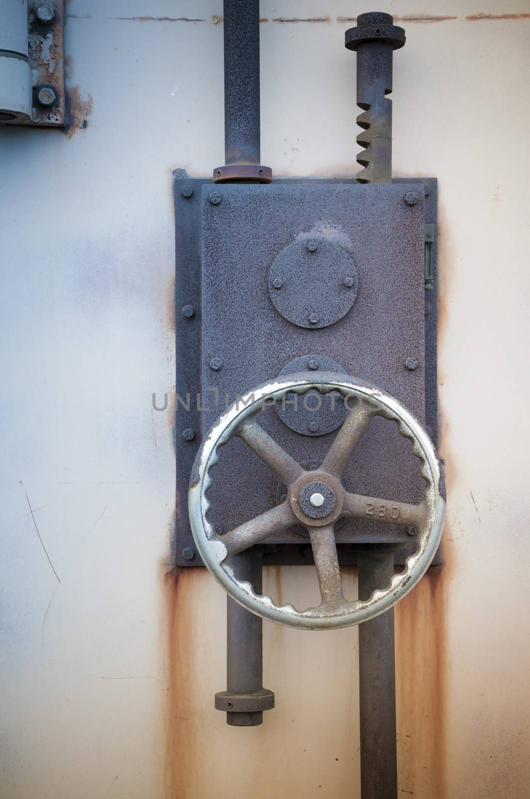 rusty iron lock on the harbour warehouse door; focus on the wheel and lock's body