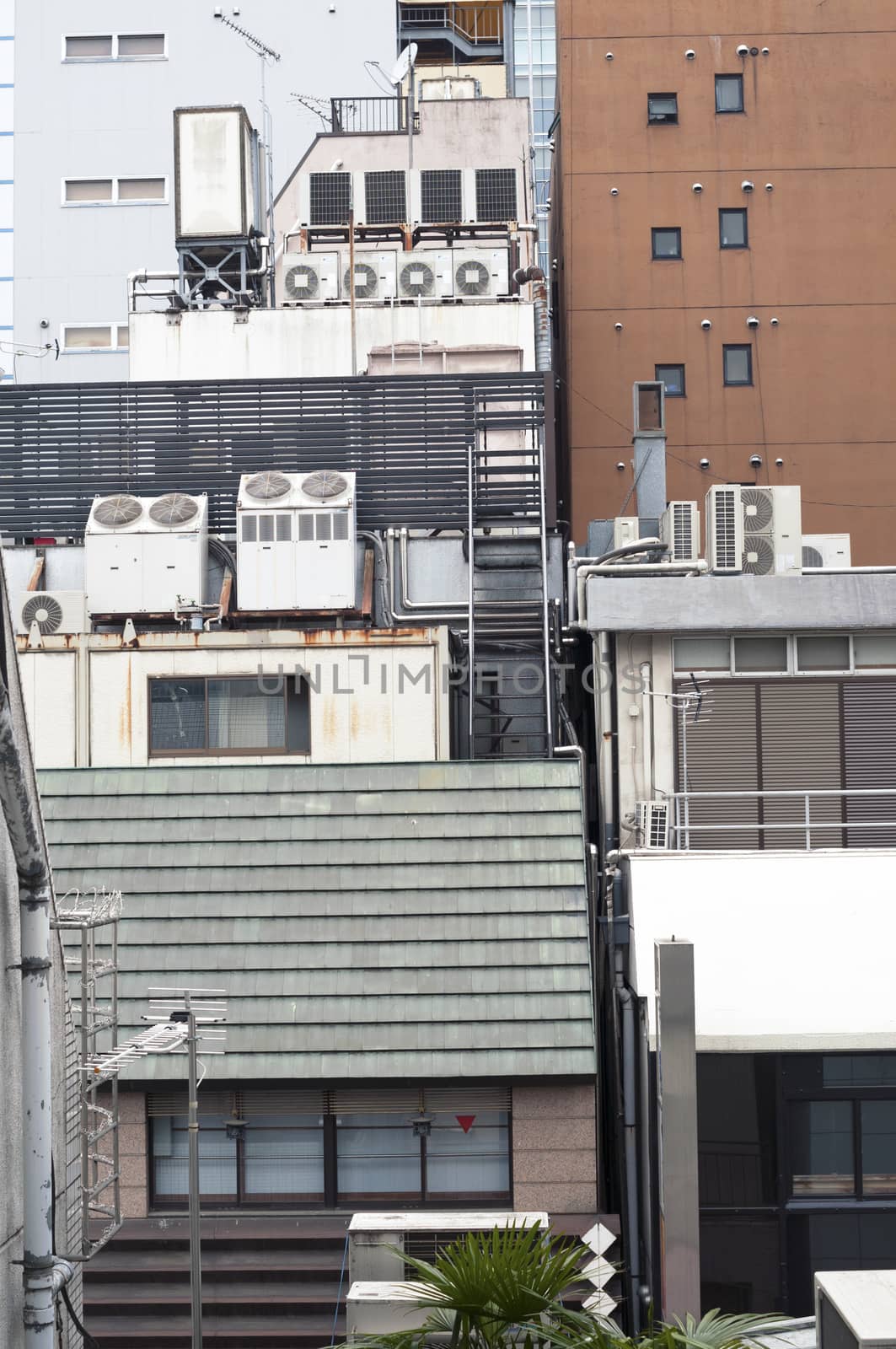 vertical city scene full of air conditioner units on the backside of modern Tokyo buildings