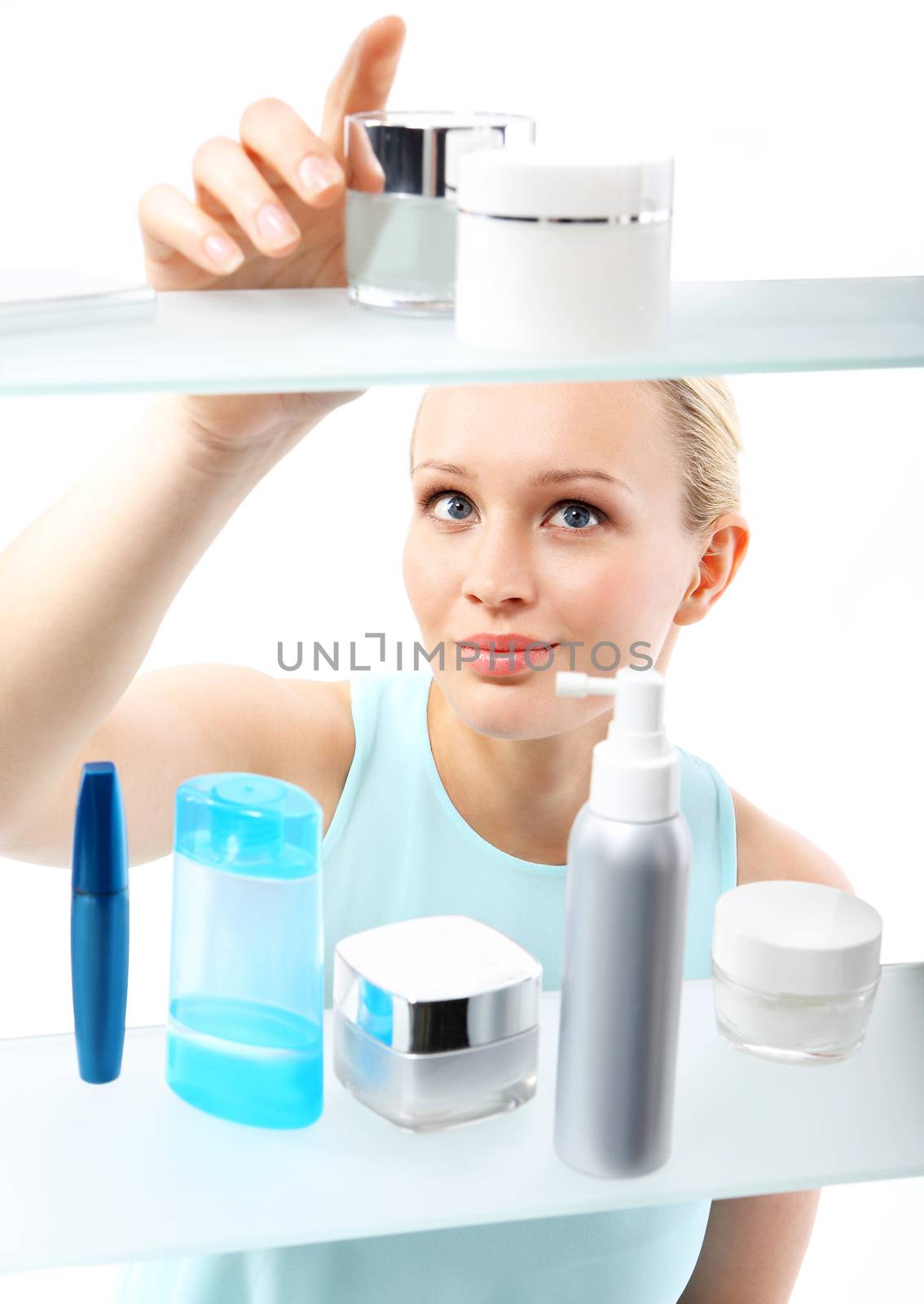 A woman stands at the client shelf and selects cosmetics. by robert_przybysz