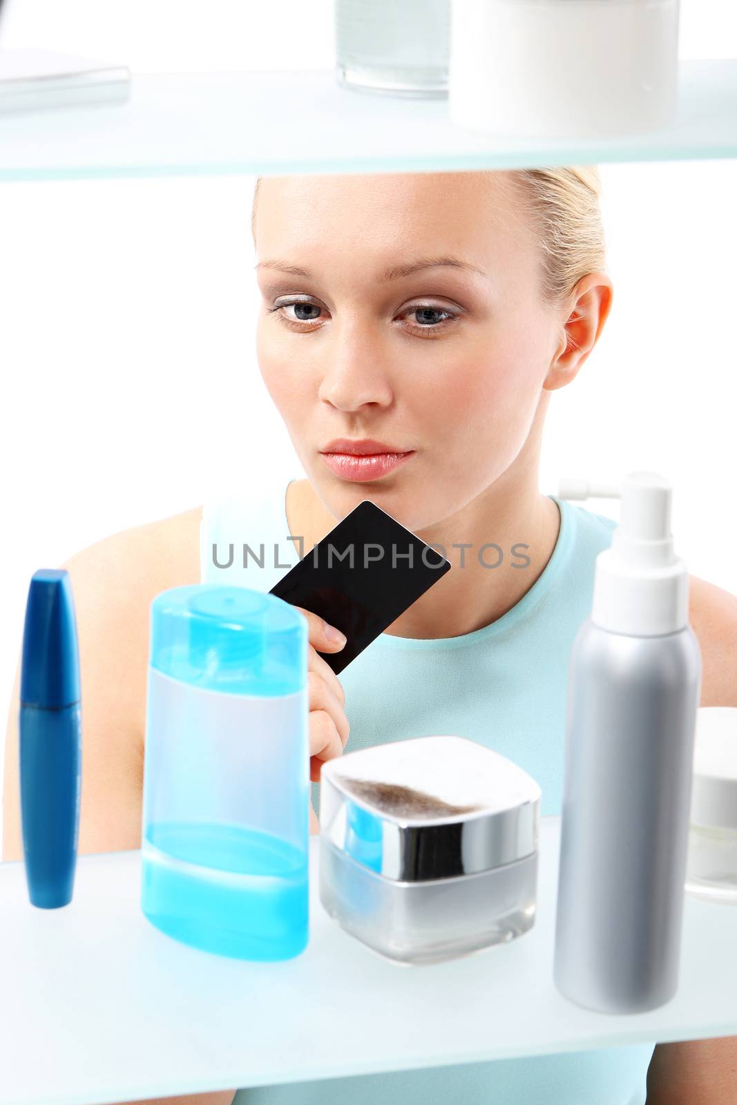 Woman buying cosmetics in drugstore. by robert_przybysz