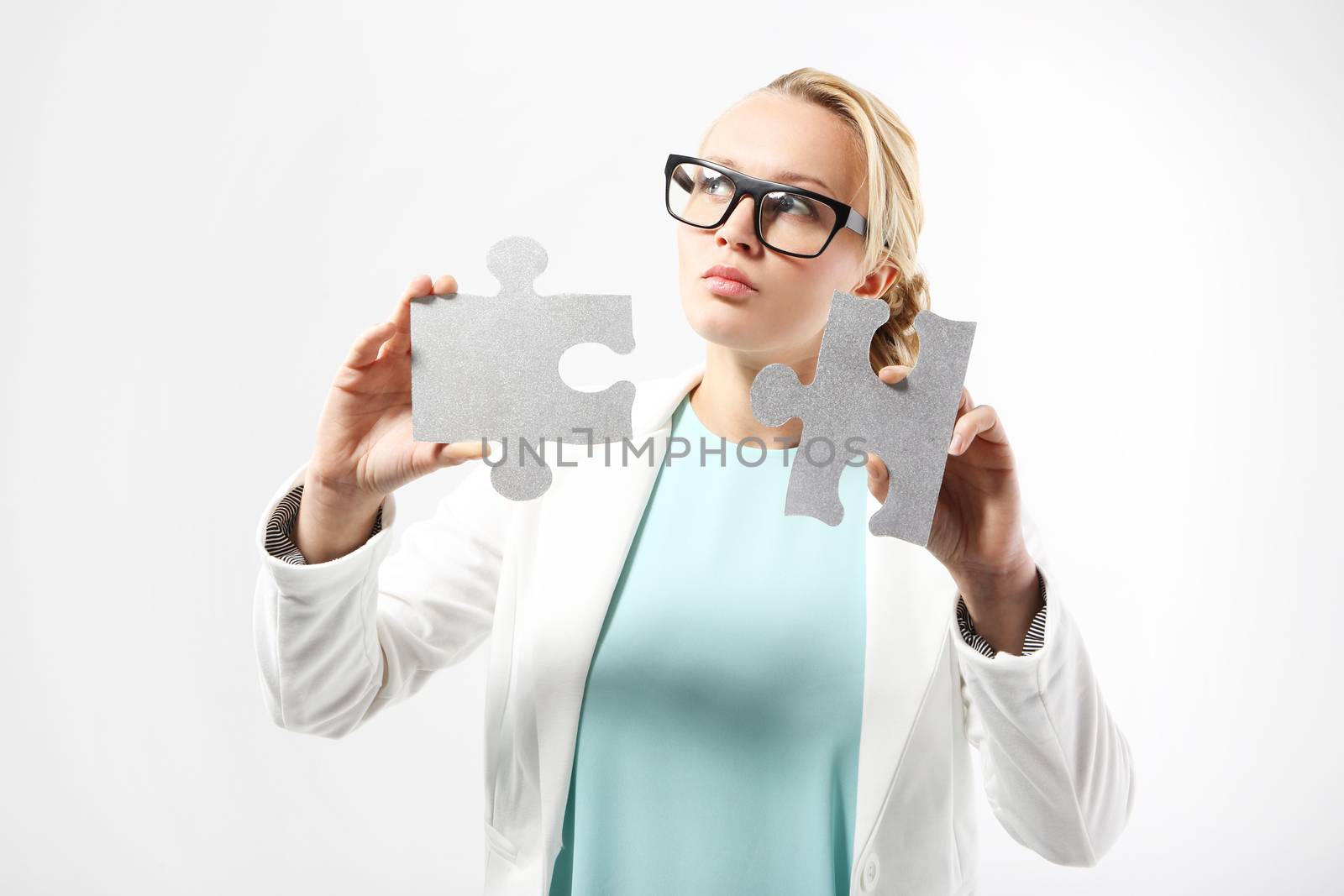 Attractive woman in business outfit adjusts the pieces of the puzzle