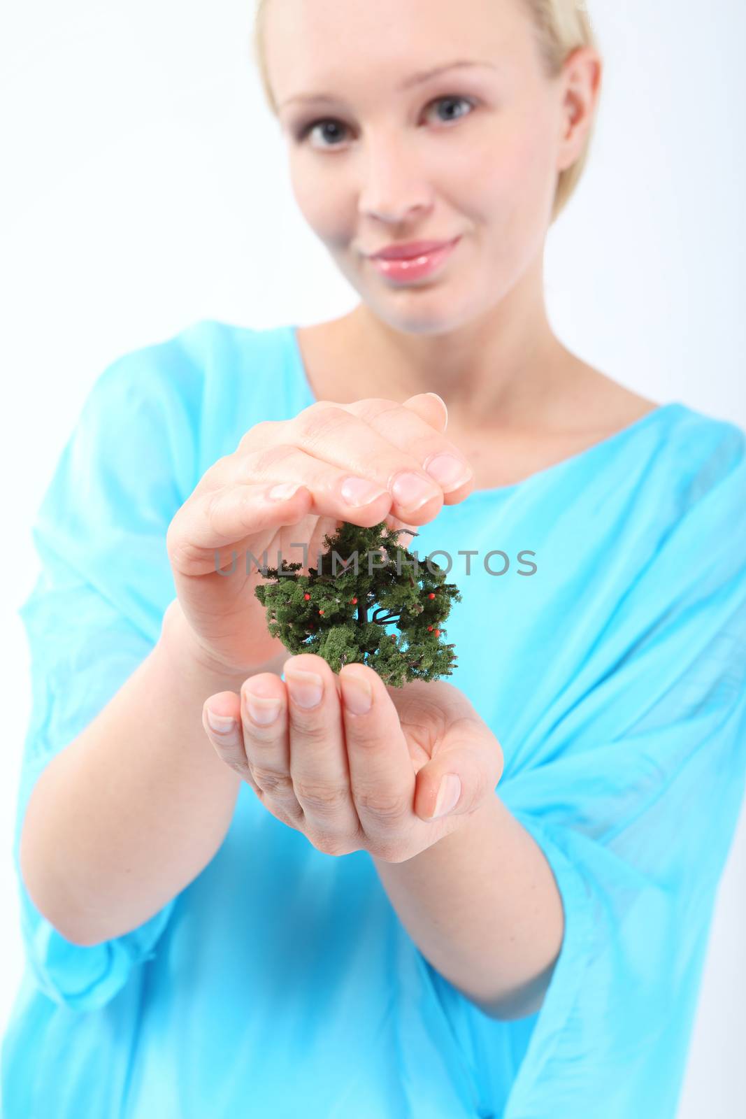 A woman holds on hands small tree by robert_przybysz