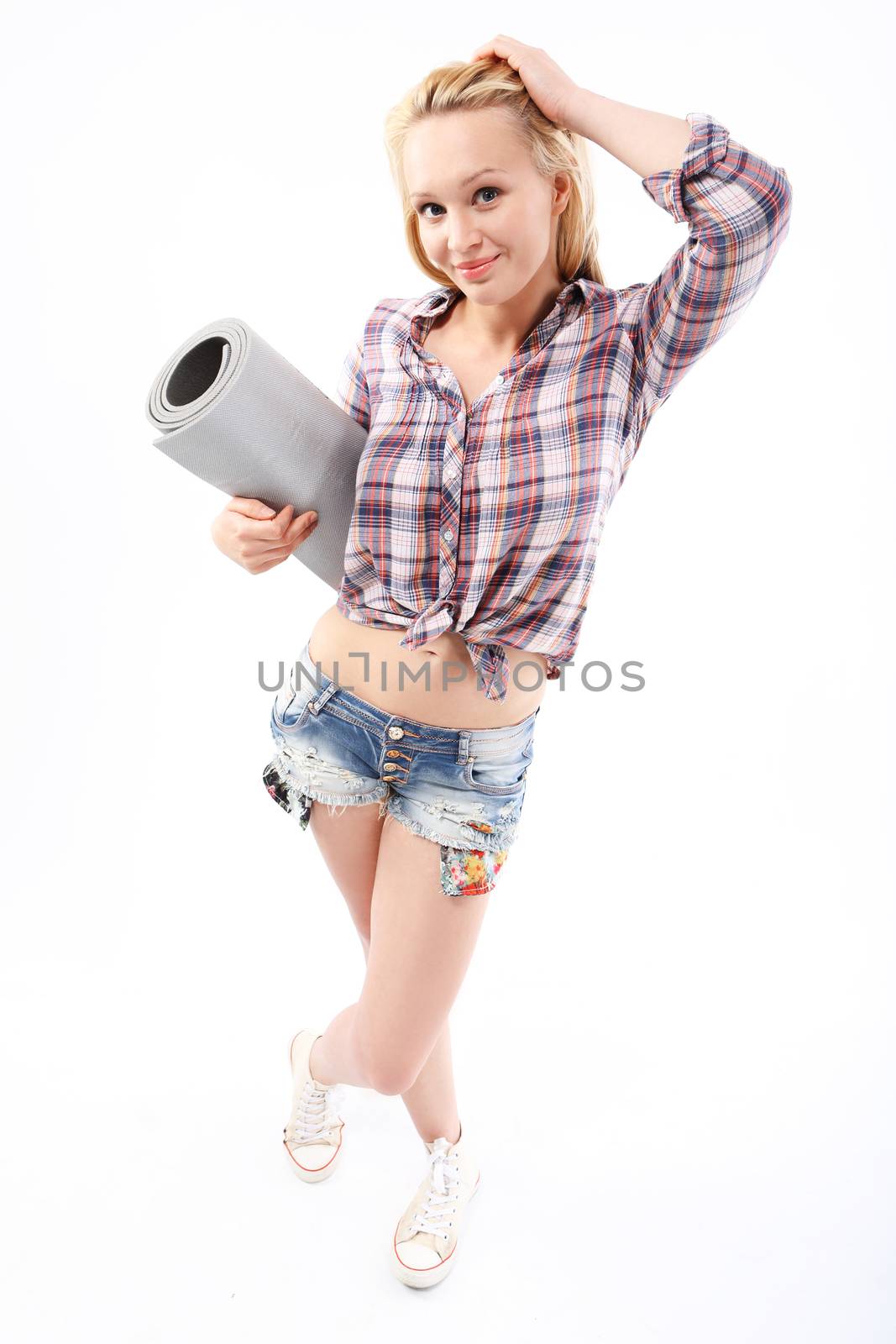 Young girl with exercise mat on a white background