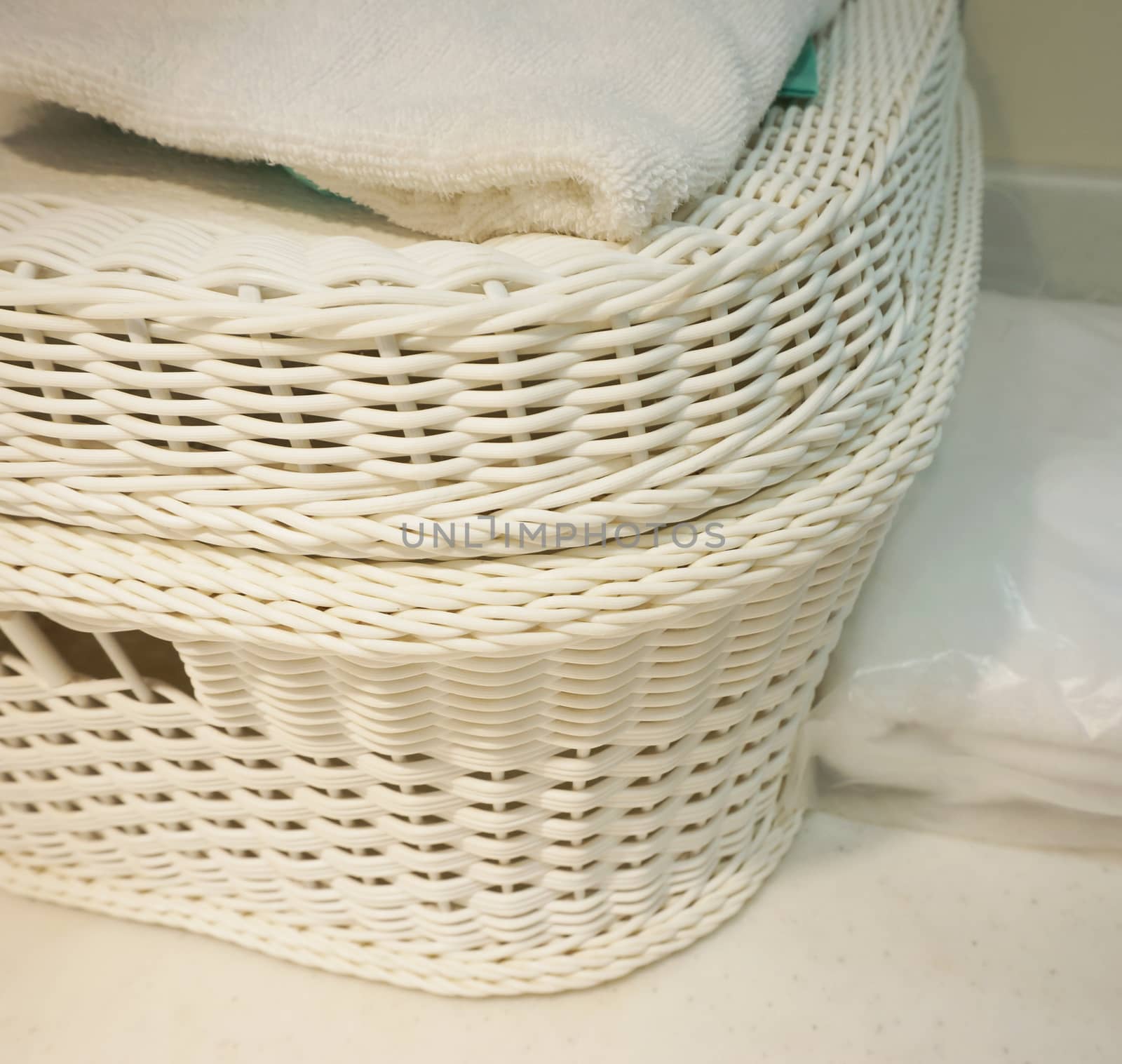 White basket with a lid. Used for clothes placed on the table in hotel.                             