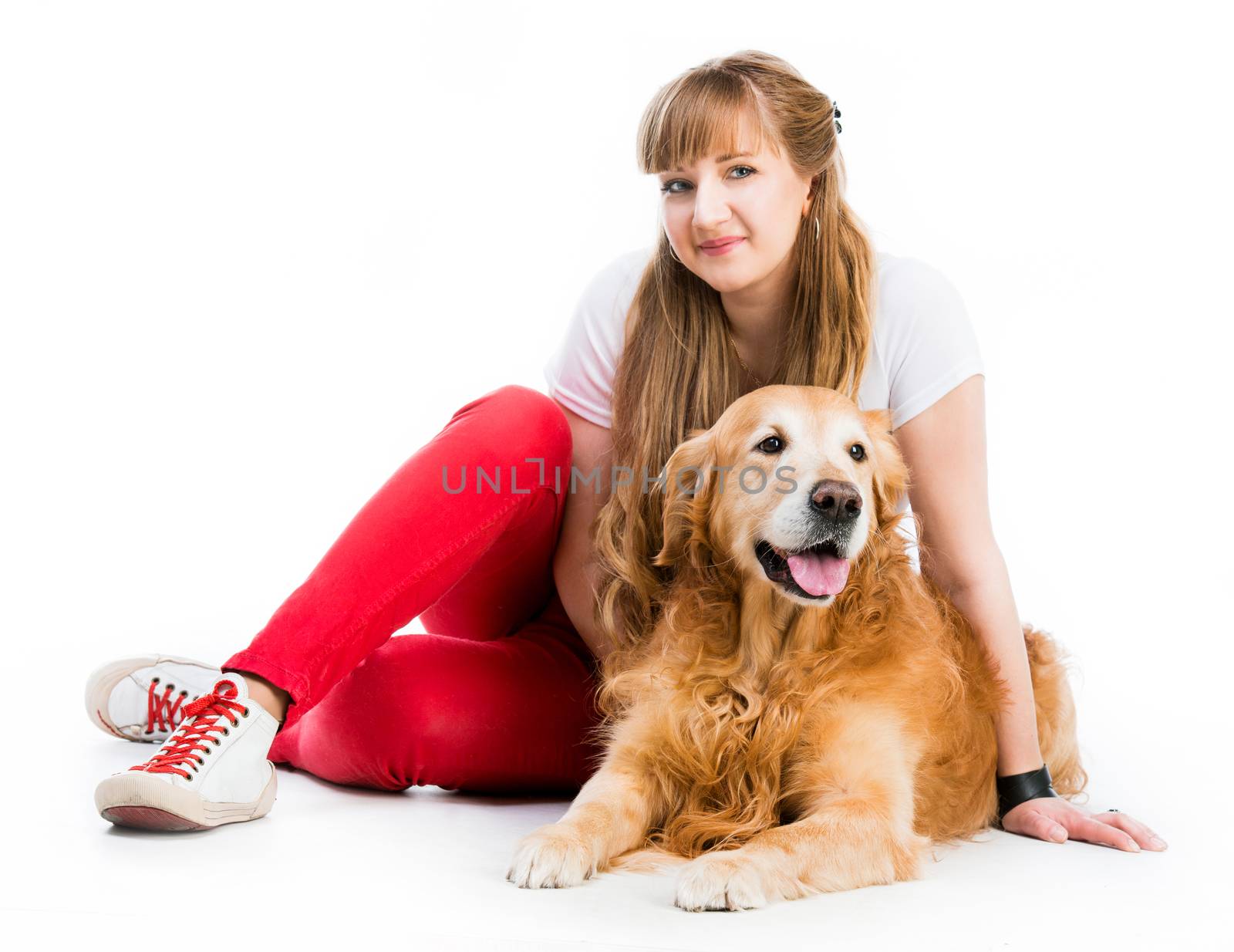 young woman with her ginger retriever seating on a white background