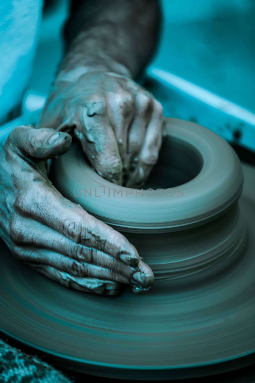 Hands working on pottery wheel ,  artistic  toned by Lizard