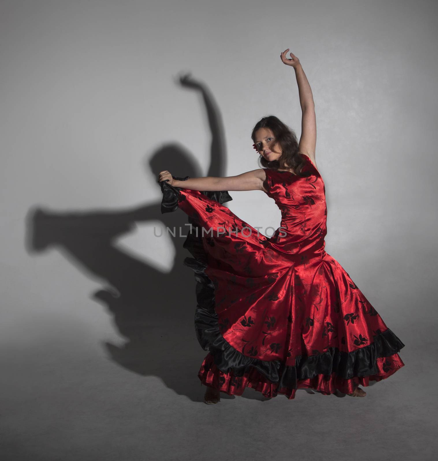 Young woman dancing flamenco, studio shot, gray background