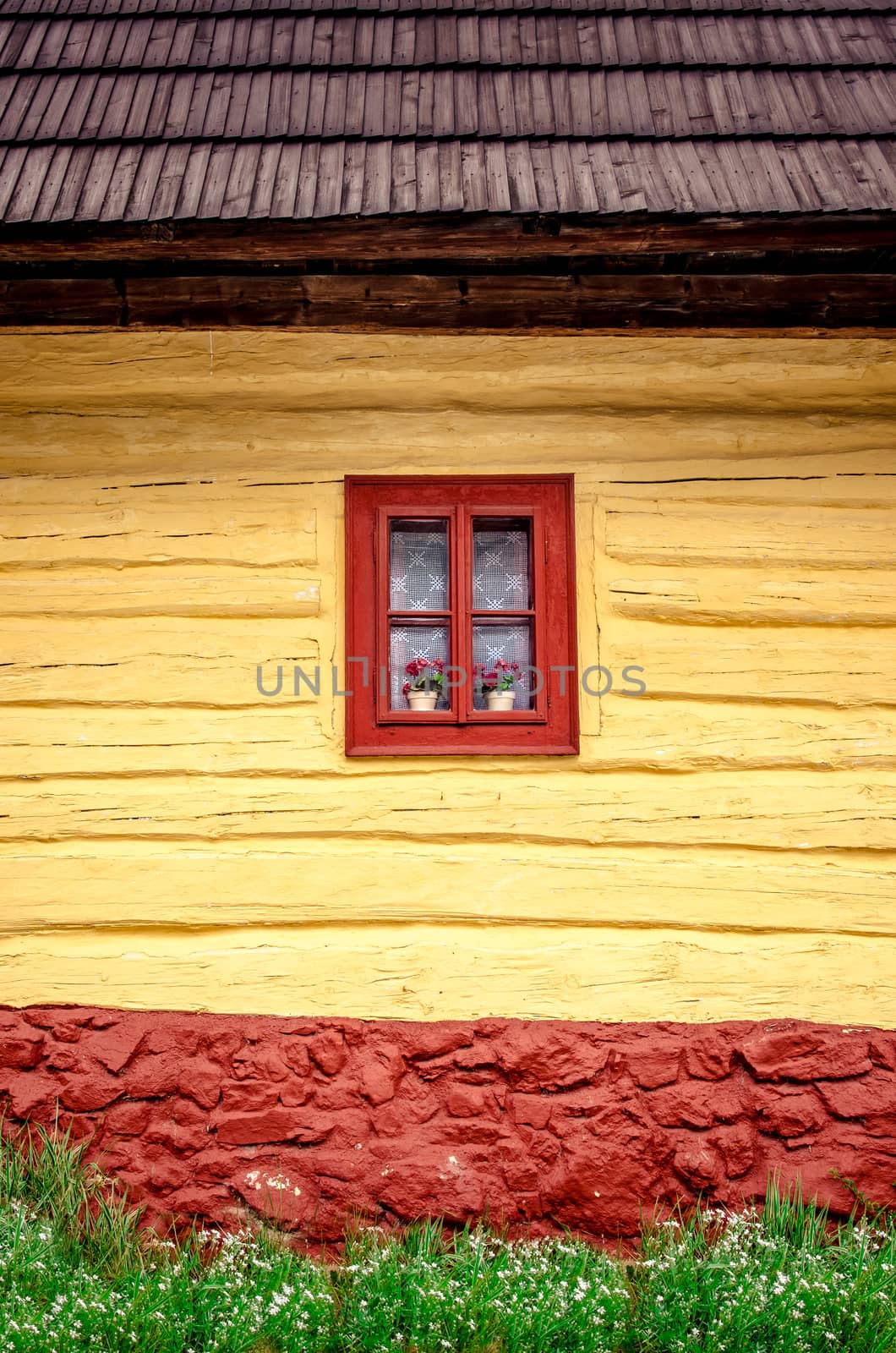Detail of colorful window with flowers on old traditional wooden house