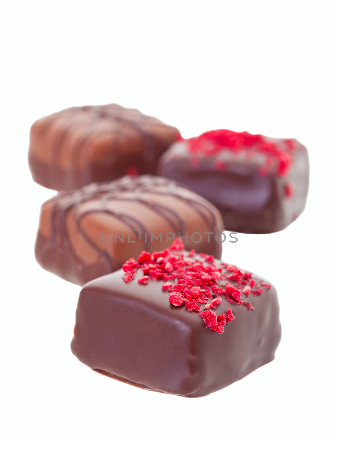 An assortment of fine chocolates on a white background.  Shallow depth of field.