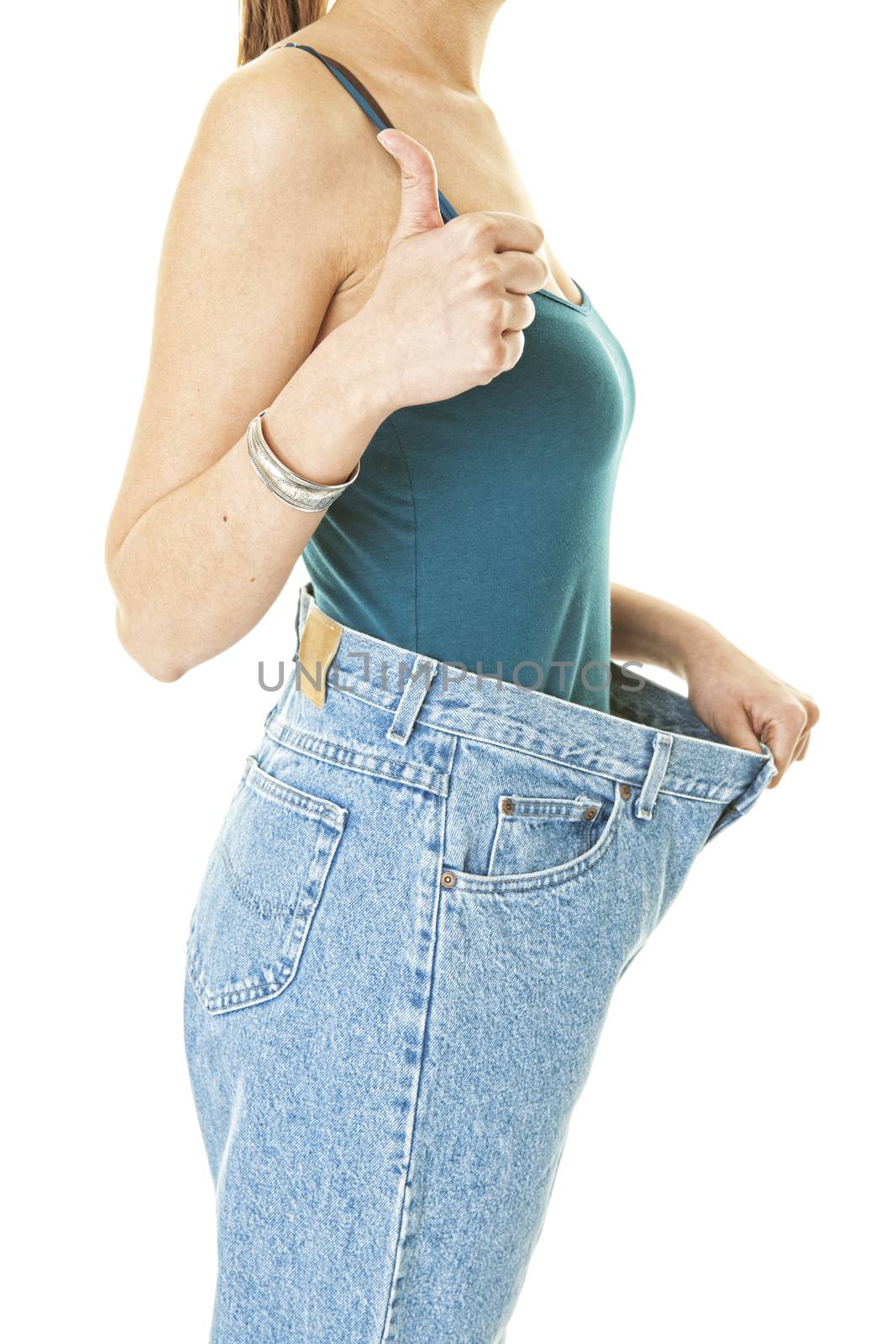  A woman showing off her dieting success.  Shot on white background.