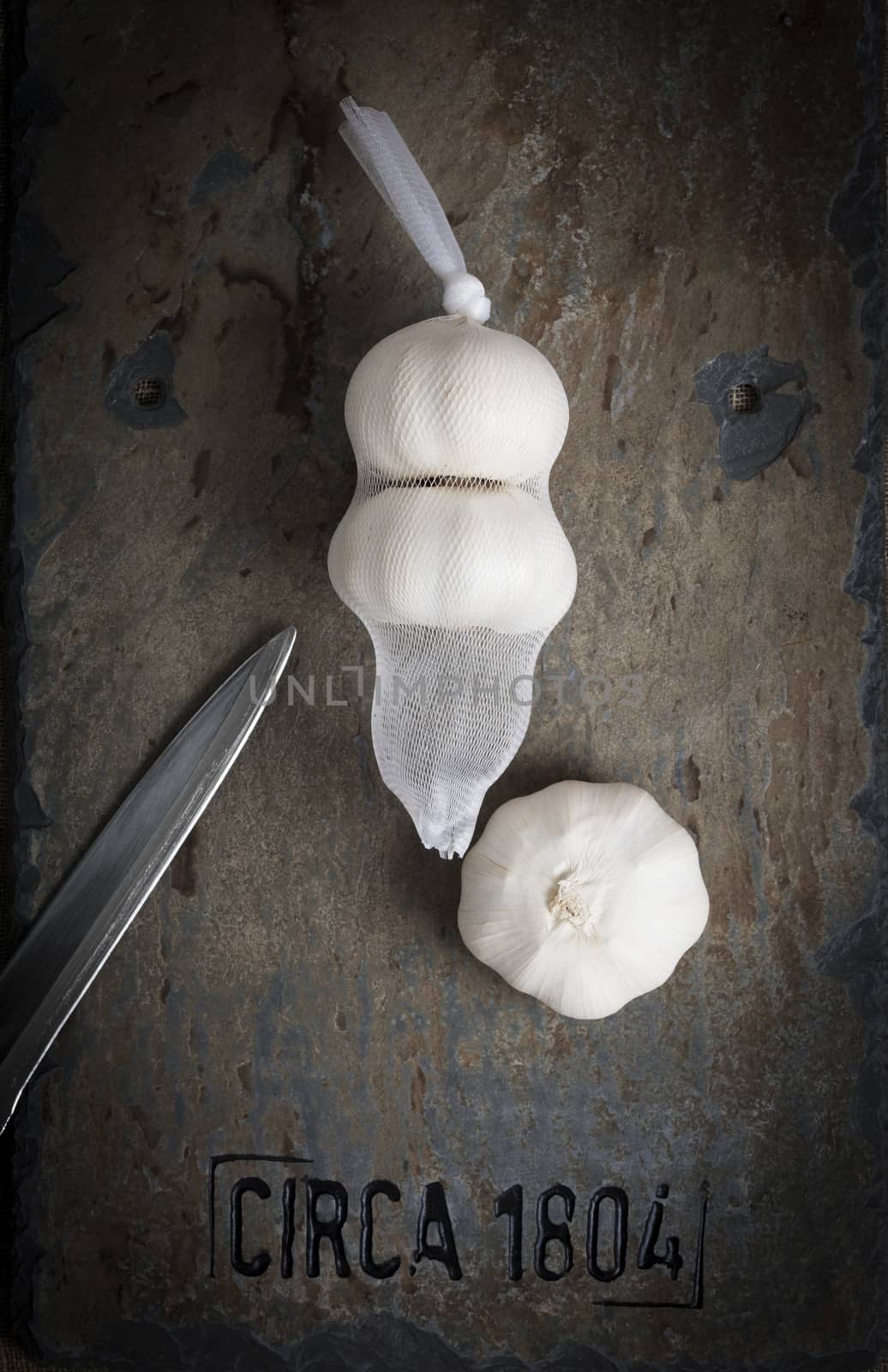 An overhead shot of garlic styled on a salvaged piece of vintage slate.  