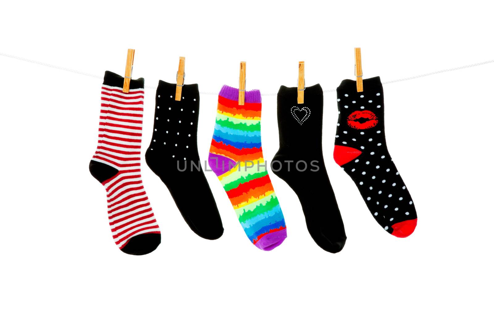 Odd socks whose mates have been lost, hanging on a clothesline.  Shot on white background.