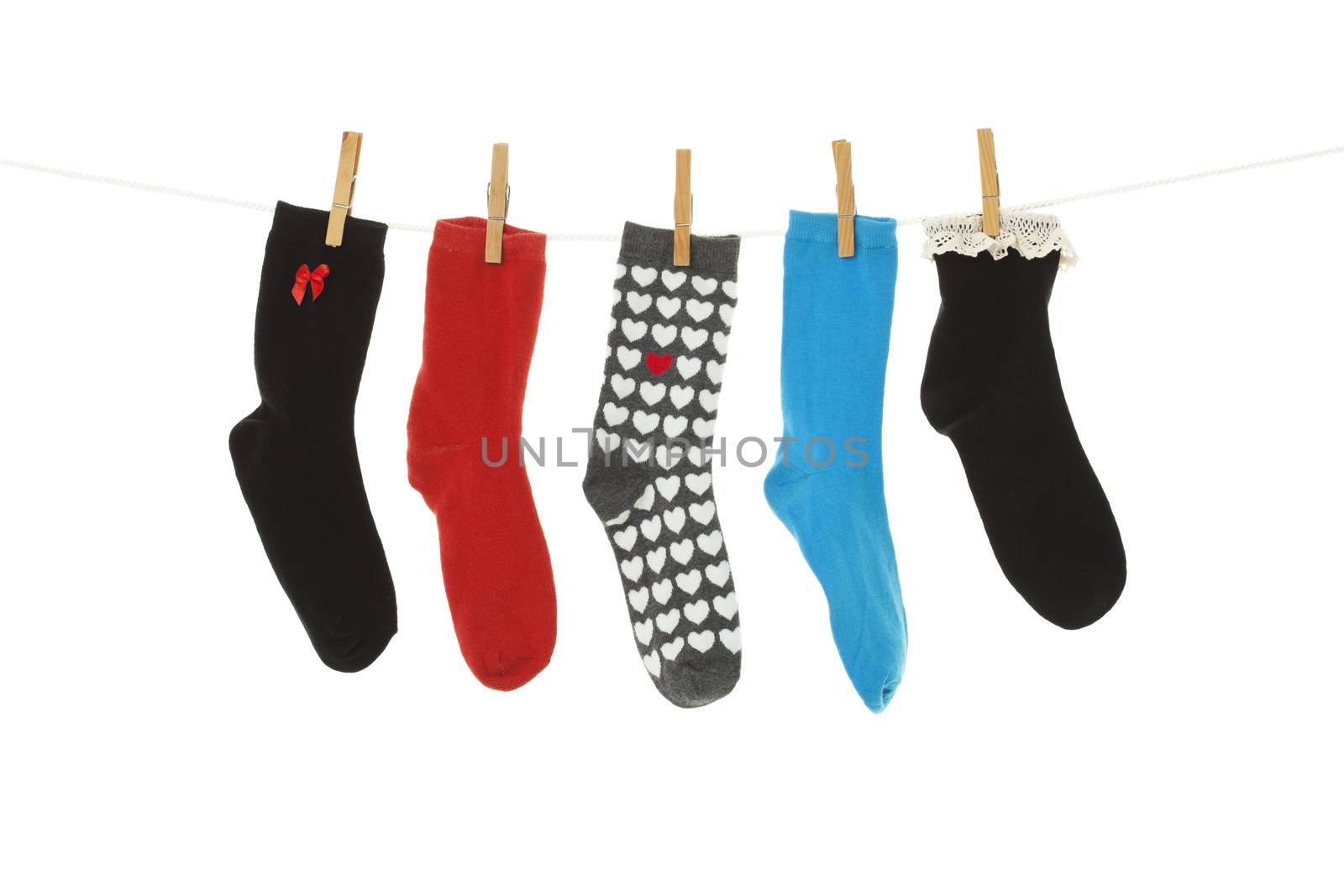 Odd socks whose mates have been lost, hanging on a clothesline.  Shot on white background.