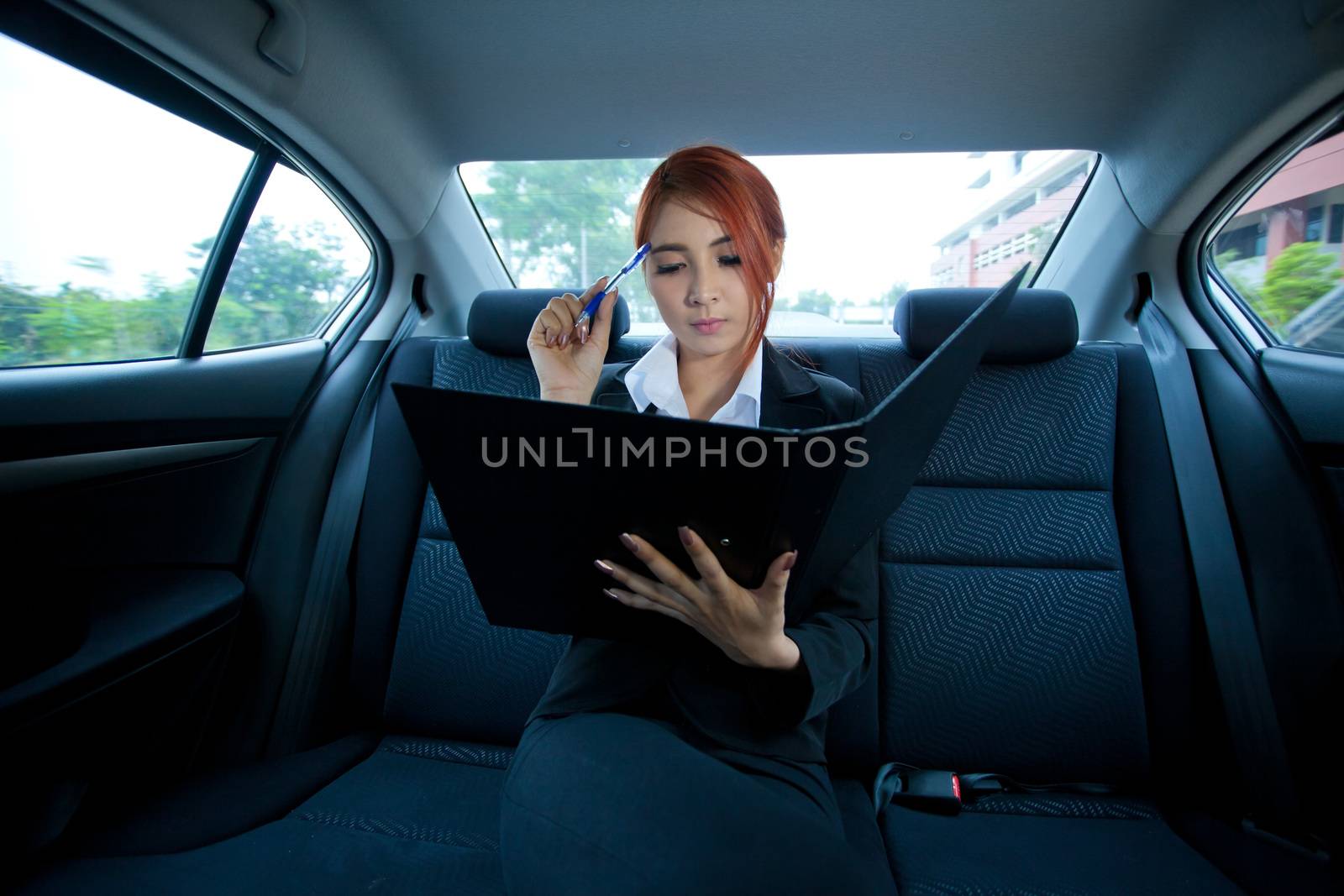 Beautiful young business asian with document in a car