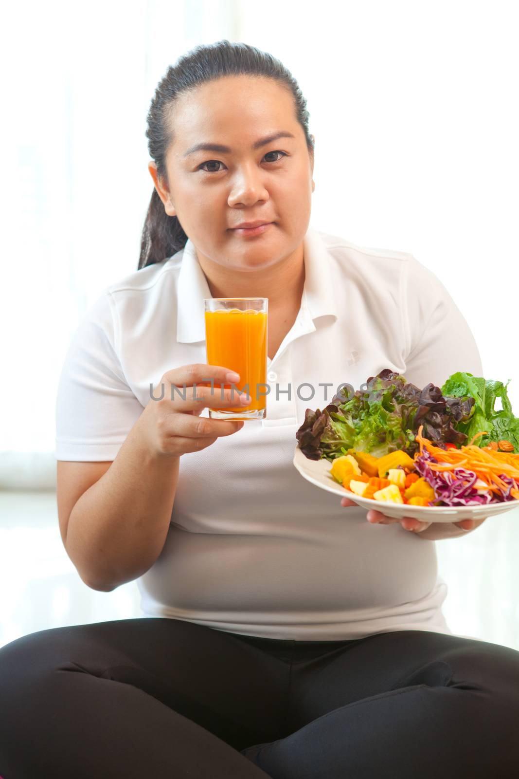 Asian fat woman eating salad on white