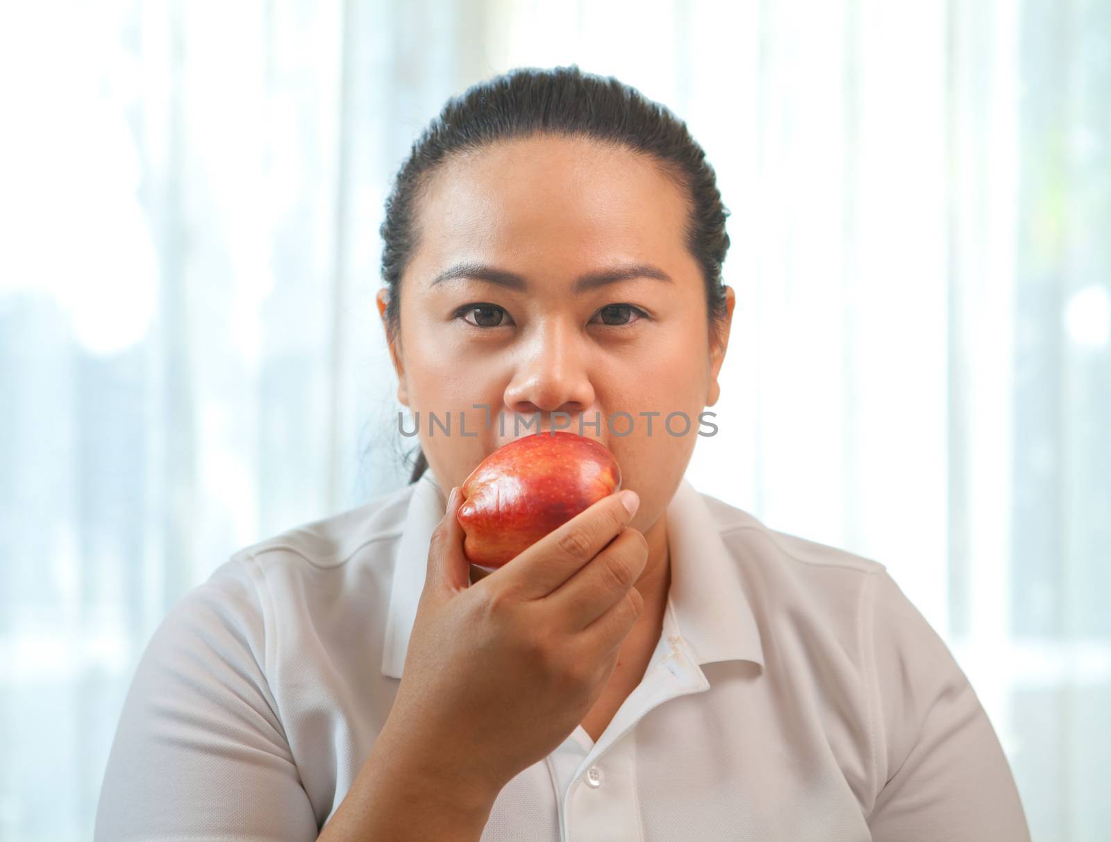 Fat asian woman with apple on white